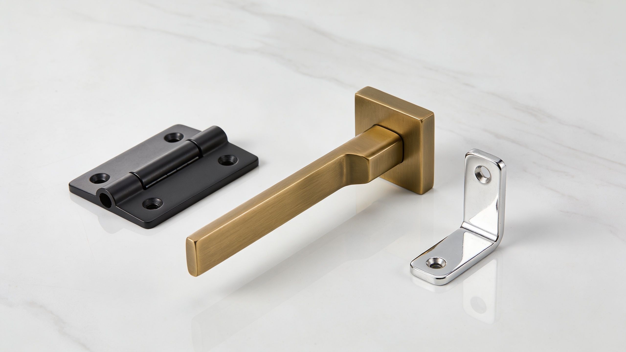 Three different styles of metal door hardware including a black hinge, brass handle, and chrome bracket.